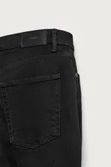 Jeans slim fit de color negro para hombre, con tiro medio, diseño de cinco bolsillos y cierre frontal con cremallera y botón.
