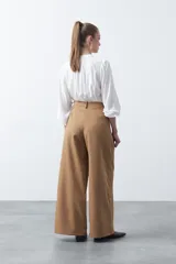 Pantalón wide leg negro de tiro alto con caída fluida y silueta amplia. Presenta cintura alta con botonadura frontal visible.
