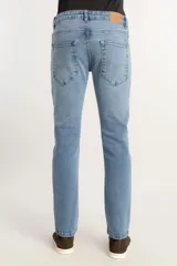 Pantalón jeans de corte slim, color azul claro con lavado light blue, confeccionado en denim premium con silueta ajustada.