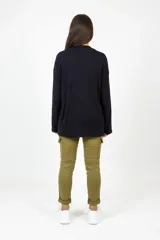 Pantalón de corte ajustado en color verde oliva, con cintura elástica y cordón de ajuste. Presenta bolsillos frontales tipo cargo y costuras transversales a la altura del muslo.