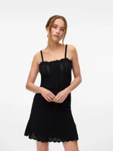 Top negro sin mangas, con tirantes finos y escote cuadrado con borde festoneado. Presenta una hilera de botones frontales y tejido de punto con patrón en zigzag.