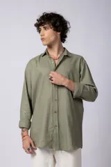 Camisa de manga larga confeccionada en lino, color verde oliva, con cuello clásico y cierre frontal de botones.