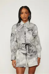 Camisa blanca con estampado de pata de gallo en negro, abotonada en el frente y de corte recto.