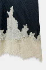 Falda midi azul marino con efecto arrugado y detalle de encaje en el ruedo. Cuenta con cintura elástica y forro interior.
