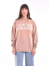 Buzo de cuello redondo, manga larga con puños elásticos y ruedo acanalado. Presenta un estampado frontal con la frase 'YOU ARE POWERFUL' en color blanco.