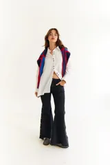 Camisa oversize de algodón color blanco, con cuello clásico, cierre frontal de botones y detalle de costuras decorativas en zigzag a lo largo de la botonera. Presenta mangas largas con puños estructurados y un diseño versátil que permite ajustar la silueta.