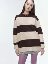Buzo tejido de corte oversize con diseño de rayas horizontales en tonos azul y celeste. Presenta cuello redondo, hombros caídos y terminaciones acanaladas en puños y bajo.
