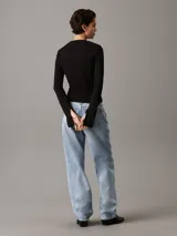 Top negro de algodón regenerativo con textura de canalé, corte slim, cuello redondo, mangas largas con puños con abertura e insignia con el monograma de Calvin Klein en el bajo.