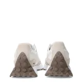 Championes urbanos New Balance modelo Lifestyle, color blanco con detalles en beige y marrón, confeccionados con superposiciones de gamuza y base sintética. Presentan el característico logo "N" en los laterales y suela dentada de goma.