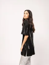 Remera blanca oversized de tela elastizada con tajos laterales y escote redondo.