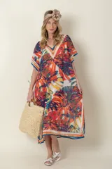 Túnica estampada con motivos de hojas en tonos naranja, blanco, azul y verde, con terminaciones en azul.