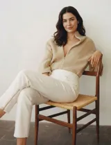 Pantalón tipo jegging de denim color blanco roto, tiro alto, corte recto al tobillo con cierre funcional en el ruedo. Diseño pull-on sin cierre ni botón frontal, con bolsillos funcionales traseros y simulados delanteros.