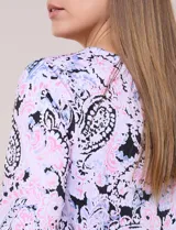 Blusa holgada de manga 3/4 con estampado paisley en tonos rosado, celeste y negro, escote en V y volados en los puños.