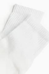 Pack de tres pares de medias blancas de punto fino, con caña corta acanalada y borde superior elástico.
