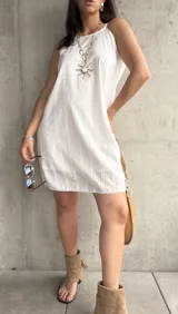Vestido corto blanco con bordado calado, tirantes finos y corte recto.