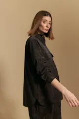 Sobrecamisa de efecto engomado en color negro, con textura lavada, cuello clásico, cierre frontal con botones a tono y bolsillos frontales con solapa.