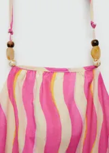 Vestido midi de algodón con diseño estampado de ondas verticales en tonos rosa y crema. Presenta cuello halter con detalle de abalorios, espalda descubierta, aberturas laterales tipo cut-out en la cintura y falda evasé.