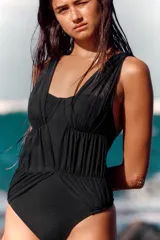 Malla enteriza negra con aros, escote corazón y tirantes anchos. Presenta detalles de tejido superpuesto estilo tul fruncido en el cuerpo.