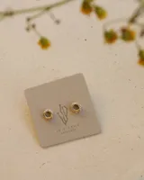 Par de aros dorados con forma cuadrada irregular y centro hueco.