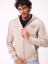 Canguro gris con capucha, cierre frontal completo y bolsillos tipo canguro. Presenta detalles de líneas blancas en las mangas y estampados gráficos en el pecho.