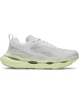 Championes de running Under Armour modelo Halo Racer, color blanco con detalles en amarillo pálido. Presentan una parte superior de malla transpirable, amortiguación UA HOVR+ para retorno de energía y una suela de goma duradera con diseño ergonómico.