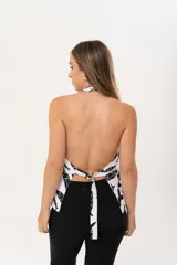 Chaleco de lino con escote en V, sin mangas y espalda abierta. Presenta un estampado exclusivo de peces en color negro sobre fondo blanco.