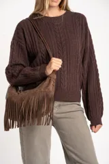 Sweater de lana y nylon color marrón oscuro, con diseño de punto trenzado (cable knit) y cuello redondo. Presenta un calce oversize.