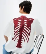 Remera de corte oversized confeccionada en mezcla de algodón y poliéster, con cuello redondo y mangas cortas. Presenta un estampado frontal con lettering estilo gótico y un estampado de esqueleto en la espalda.