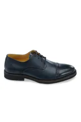 Zapato de vestir tipo oxford de cuero color azul marino, con detalles de perforaciones estilo brogue en la puntera y laterales. Cuenta con cordones al tono y suela de goma robusta.