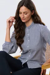Camisa de manga larga con diseño de rayas verticales en azul y blanco, cuello mao y cierre frontal con botones.