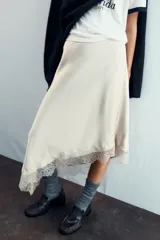 Falda color crema de satén con corte al bies y terminación asimétrica con encaje.