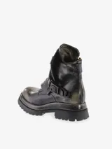Bota corta de cuero bovino con efecto desgastado y envejecido en tonos negro y gris. Presenta caña arrugada, cierre lateral y una correa ancha con hebilla metálica. La suela es gruesa y dentada, con efecto plataforma.