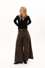 Pantalón de jean de tiro alto con corte wide leg y diseño de paneles verticales. Presenta un acabado lavado con efecto desgastado en tono chocolate, bolsillos funcionales y cierre frontal con botón metálico.