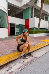 Top deportivo azul con contorno y tirantes blancos, banda inferior blanca con logo en rojo y borde inferior rojo.