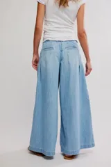 Pantalón de denim celeste de tiro bajo, pierna muy ancha y diseño sastrero con tablas al frente. Cuenta con cintura fruncida en la espalda, bolsillos y cierre frontal con cremallera y gancho.