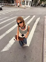 Chaleco calado negro con diseño de rayas diagonales rojas, beige y blancas.