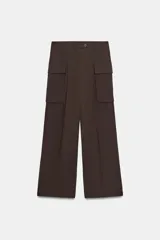 Pantalón cargo de tiro medio en color marrón oscuro, con corte recto y amplio. Presenta bolsillos laterales tipo cargo con solapa y detalle de pliegues frontales. Cierre frontal con cremallera y botón.