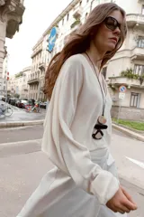 Collar de cordón negro con colgante triple de piezas de resina. La pieza superior es ovalada y beige translúcida, la del medio es rectangular y negra opaca, y la inferior es irregular con un patrón de remolino blanco y negro. El cierre es ajustable con una bola metálica.