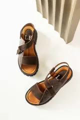 Sandalias de plataforma con suela track, confeccionadas en una combinación de cuero liso y cuero con textura croco. Presentan tiras anchas en el empeine y cierre con hebilla ajustable en el talón.