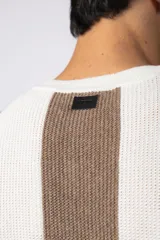 Remera de tejido de punto con textura piqué, de manga corta y corte relajado. Presenta un diseño de rayas verticales en tonos blanco, negro y marrón.