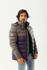 Campera puffer de abrigo con diseño bicolor, gris en la parte superior y violeta oscuro en la inferior. Cuenta con cierre frontal completo, capucha desmontable, bolsillos laterales con cierre y logo estampado en el pecho.