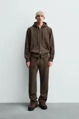 Pantalón jogger de corte regular fit y color negro, confeccionado en tejido compacto de algodón con interior de rizo. Cuenta con cintura elástica, bolsillos frontales y un bolsillo trasero de doble vivo.