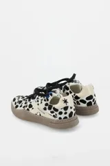 Zapatillas urbanas de cuero con paneles en gamuza negra y detalles en cuero color crema. Presentan suela de goma texturizada en tono marrón y cordones bicolores.