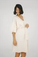 Bata maternal de algodón suave con diseño envolvente, escote en V y lazo ajustable en la cintura. Presenta mangas cortas holgadas y una silueta adaptable ideal para el embarazo y la lactancia.