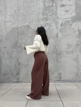 Pantalón de calce cómodo color marrón, con cintura elástica en contraste color crema, bolsillos laterales funcionales y diseño con recortes y costuras overlock a la vista.