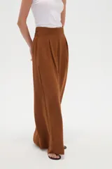 Pantalón ancho de poliéster color marrón, de tiro alto con pinzas en la cintura y punto smock en la parte posterior.
