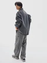 Camisa de denim de manga larga con cuello clásico, cierre frontal de botones y diseño oversize con lavado tipo washed.