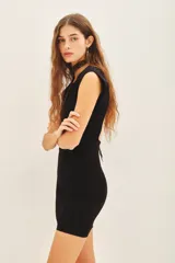 Vestido corto de punto color negro, con diseño sin mangas, cuello redondo y espalda descubierta.