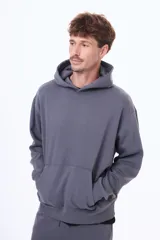 Buzo tipo canguro de felpa color gris, con capucha amplia, bolsillo frontal tipo canguro y puños acanalados.