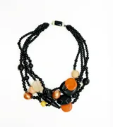 Collar de cuentas de resina en tonos negro, ladrillo y beige. Diseño de múltiples hilos con cuentas de diferentes tamaños y formas. Cierre vintage con piedra de cristal negra.